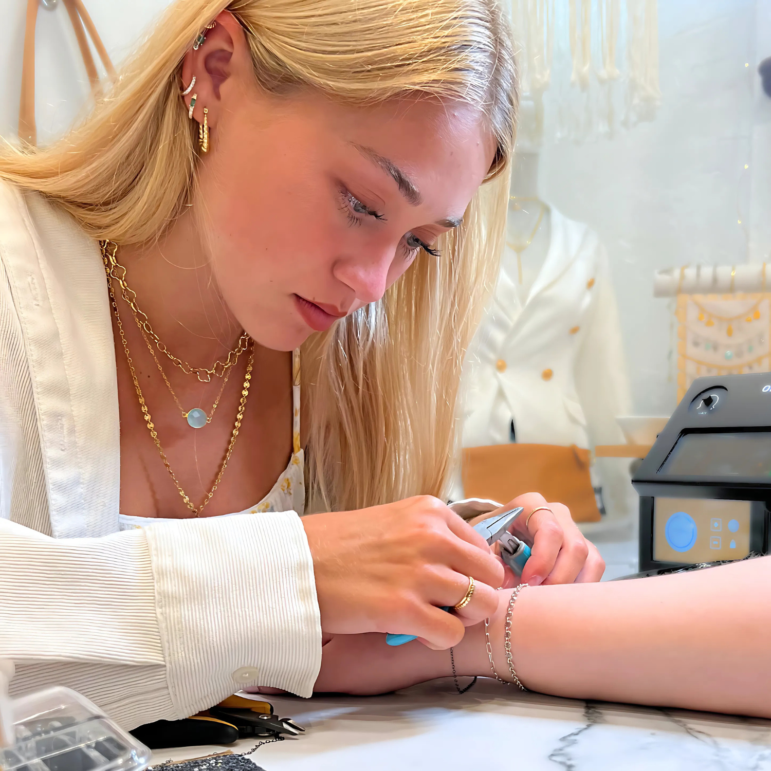 woman clasping jewelry onto clients wrist