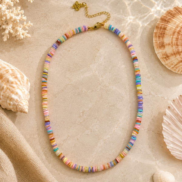 rainbow colored beaded necklace on a beachy background with seashells.