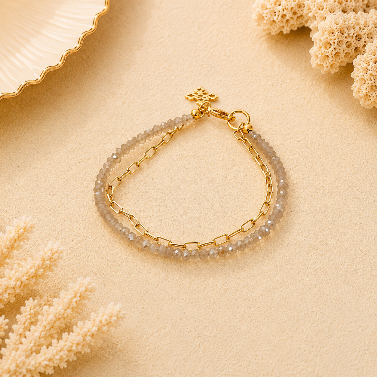 Gold bracelet with pearl-like beads on a beige surface with coral decorations