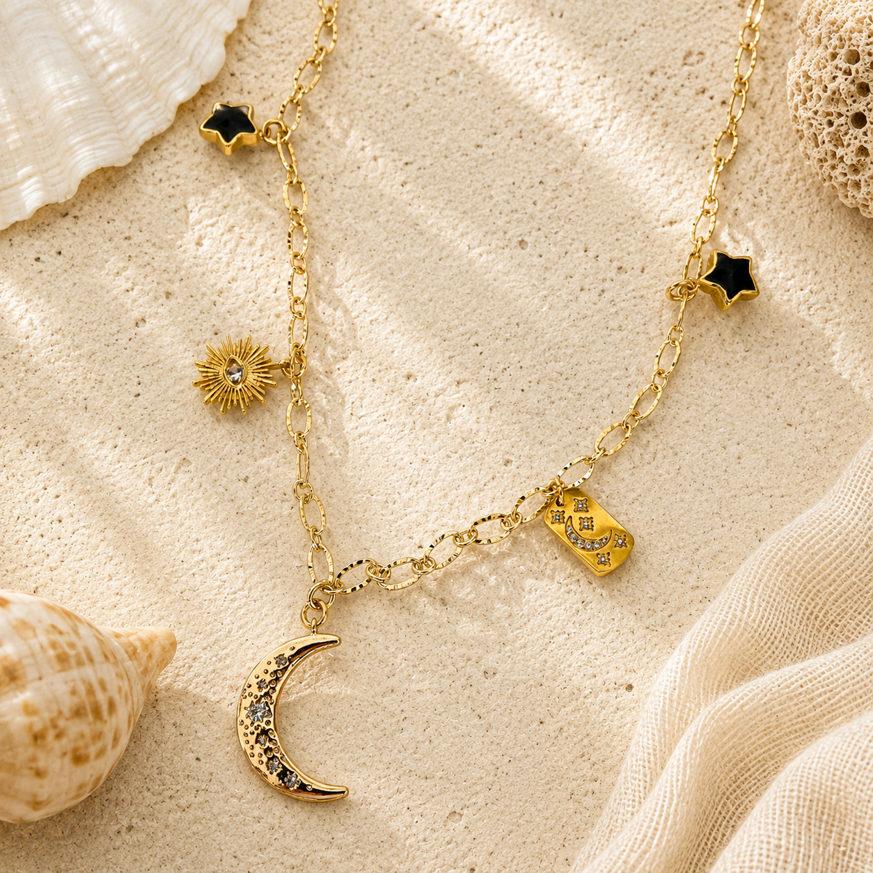 Gold charm necklace with moon, eye of protection, stars and crystal accents on a coastal background.