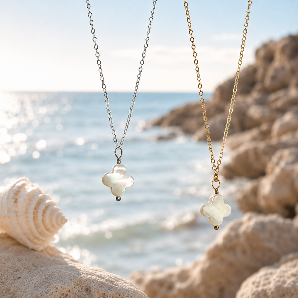 Two necklaces with shell pendants on a beach setting
