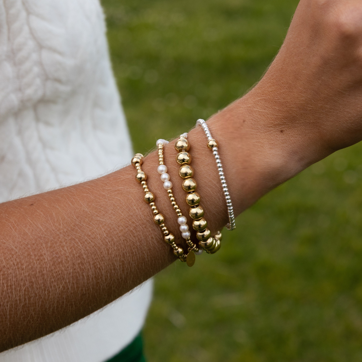 beaded stretchy bracelets mix mixed metals and pearls and one gold beaded cord bracelet.