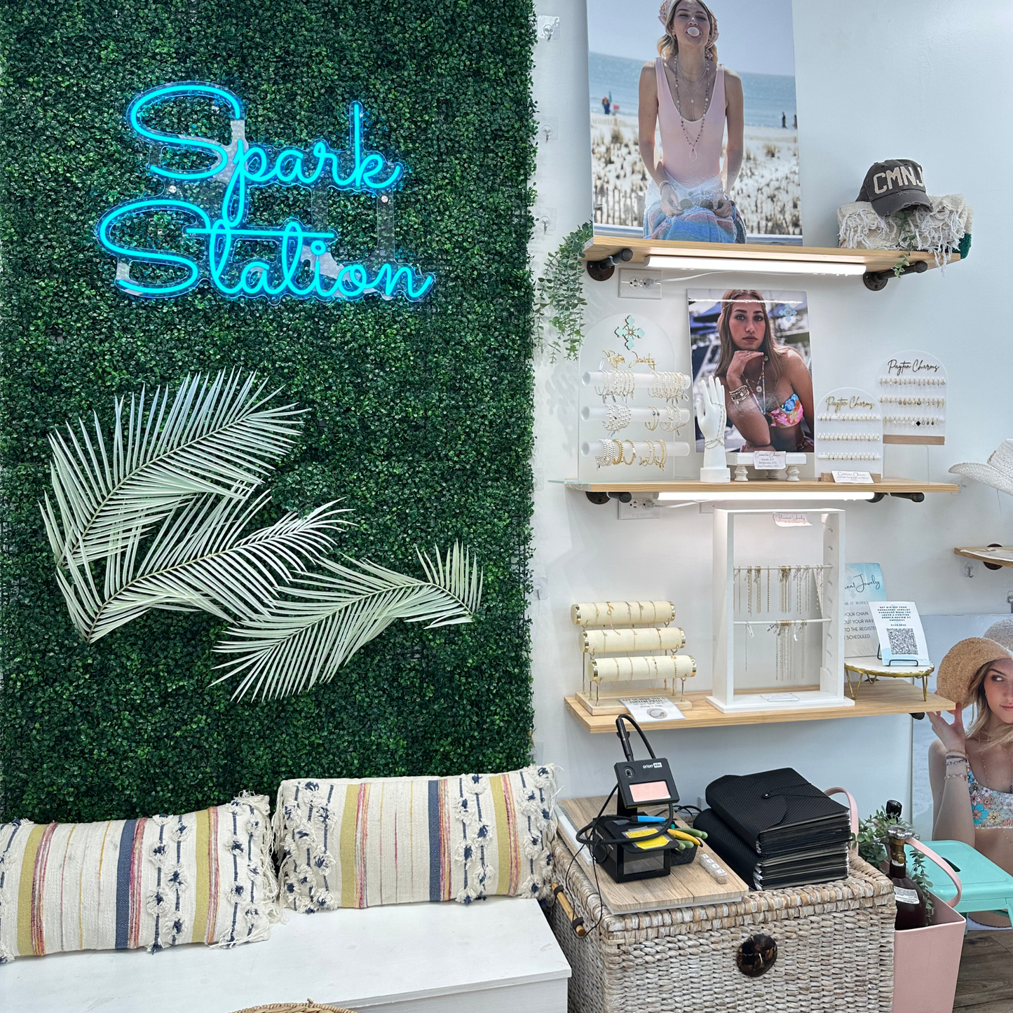 Neon sign reading 'Spark Station' in a in our Cape May location, with jewelry and a comfy bench seat.