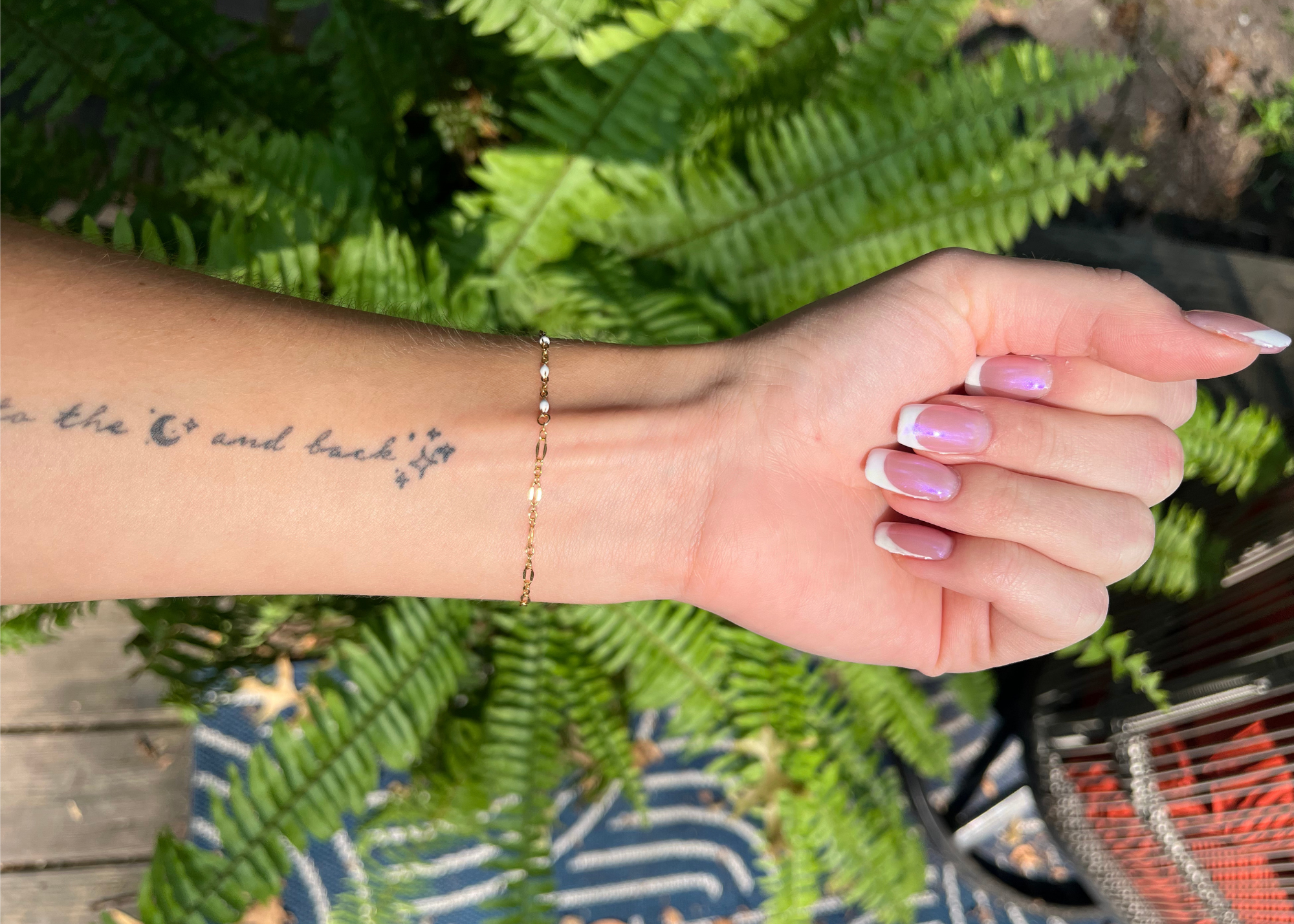 permanent jewelry bracelet in gold with white enamel.