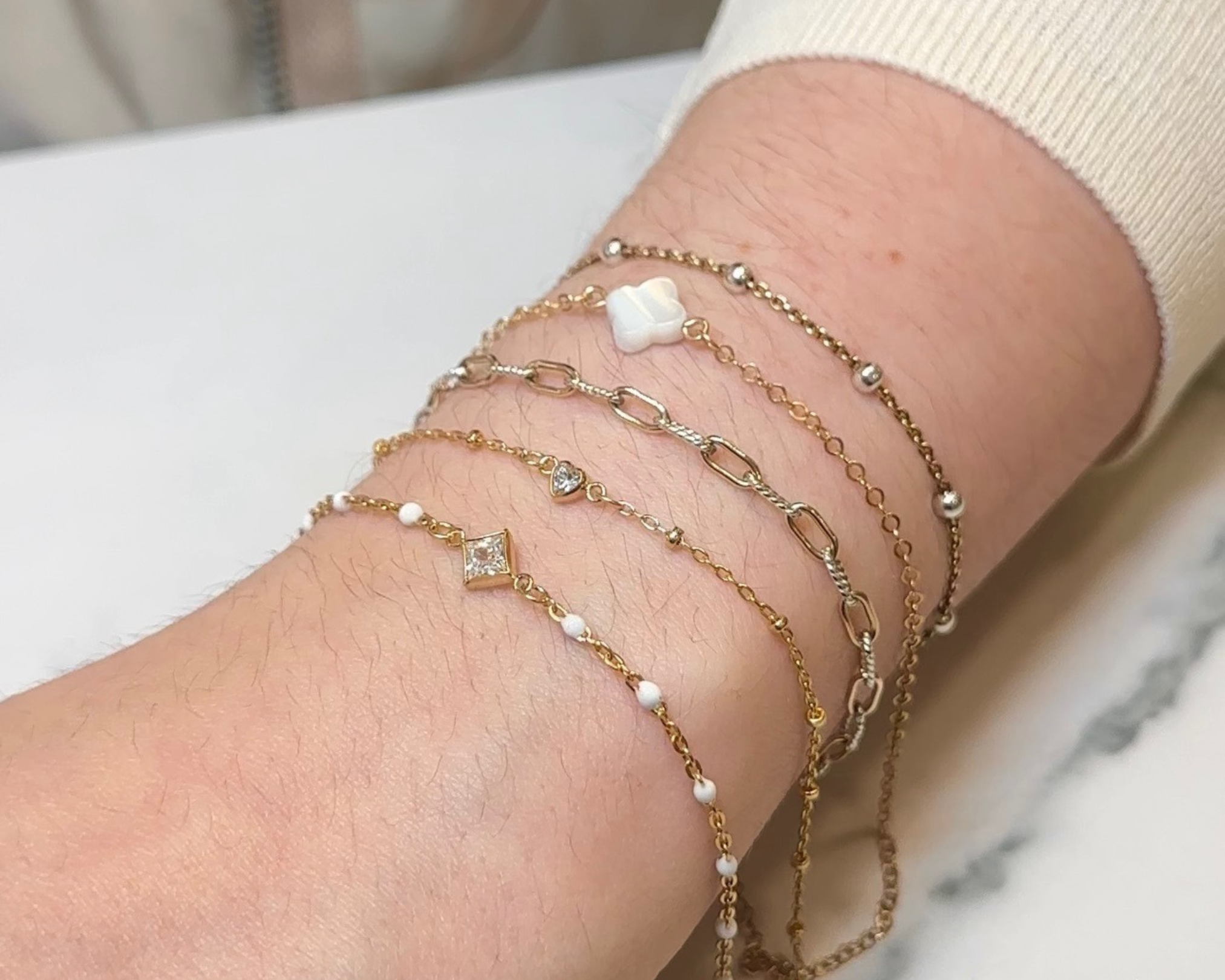 Close up of permanent jewelry chain with connector charms.