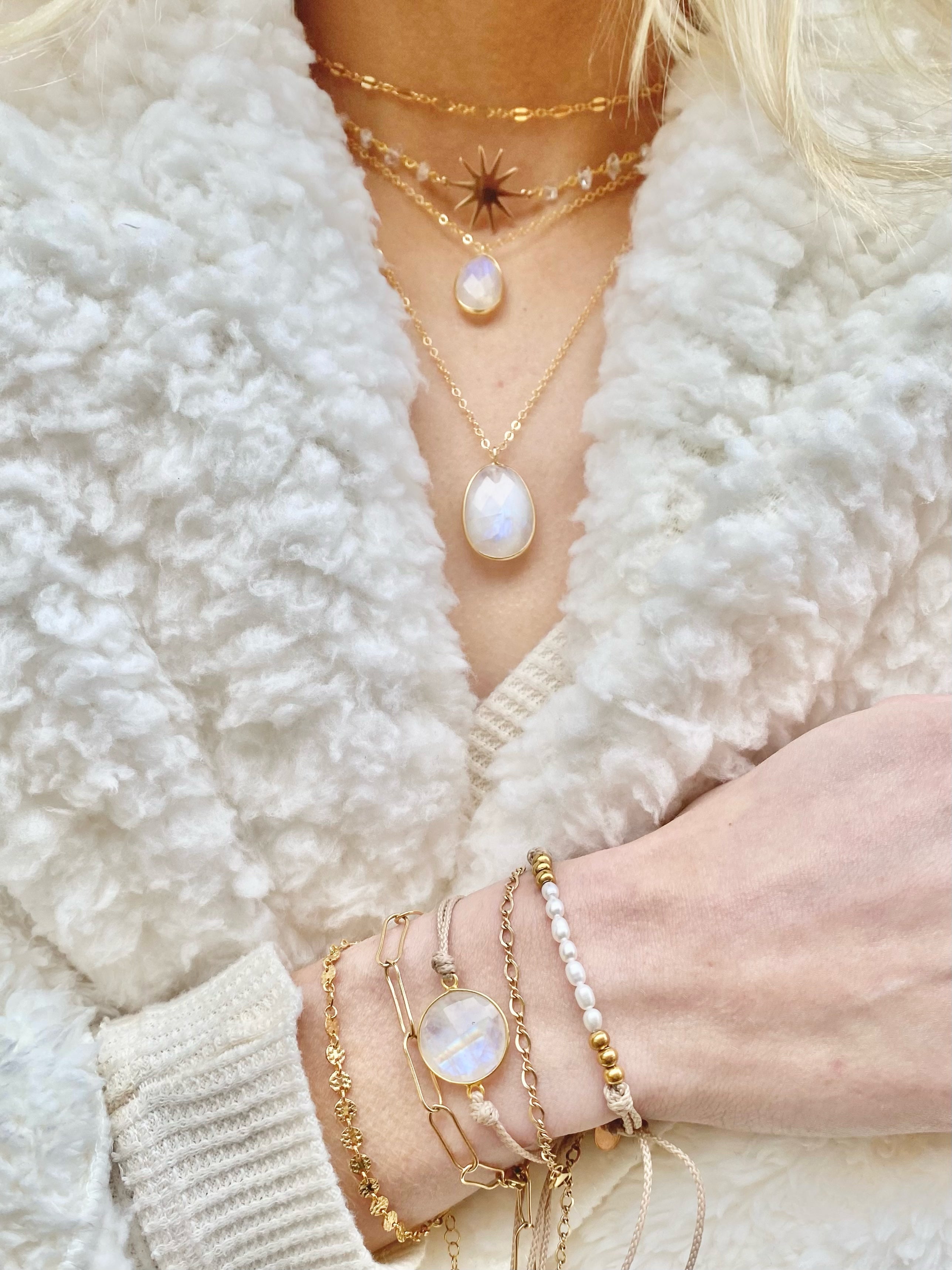 large bezel set faceted moonstone pendant necklace layered with smaller bezel set faceted moonstone necklace, starburst choker and classic link choker.